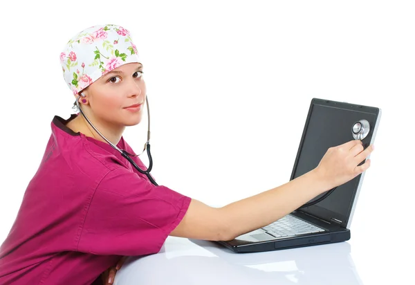 Medico donna che esamina laptop con stetoscopio — Foto Stock