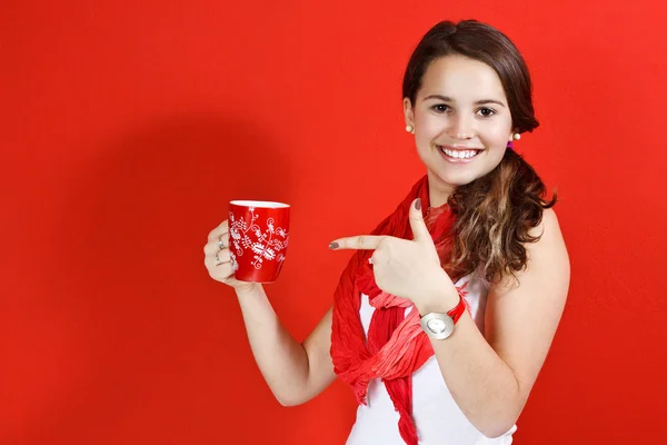 Joyeux adolescent fille pointant vers la tasse rouge — Photo