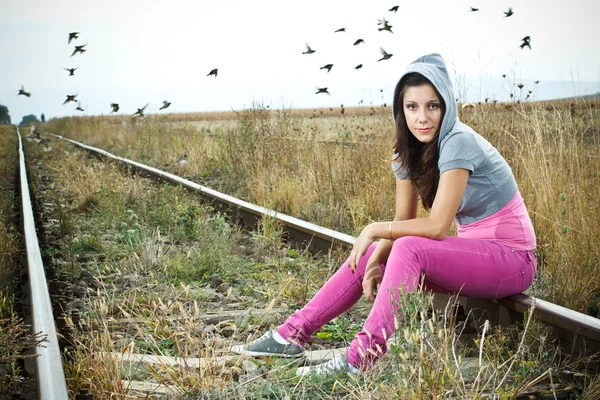 Girl sitting on railroad — Stock Photo, Image