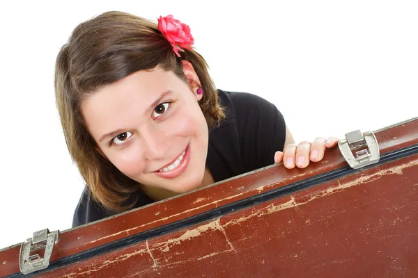 Mooie jonge vrouw die lacht achter een koffer — Stockfoto