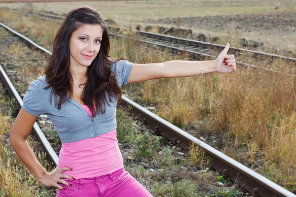 Girl hitchhiking at railroad — Stock Photo, Image