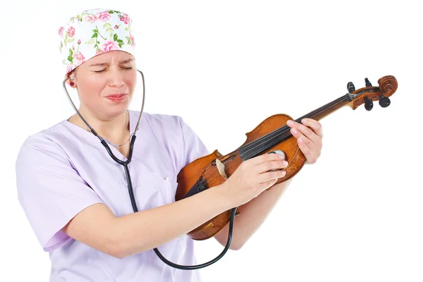 Medico donna che controlla violino con smorfia divertente — Foto Stock