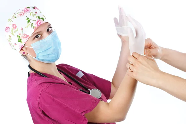 Young female doctor putting on glove — Stock Photo, Image