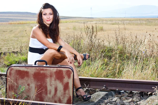 Young woman sitting on railroad — Stock Photo, Image