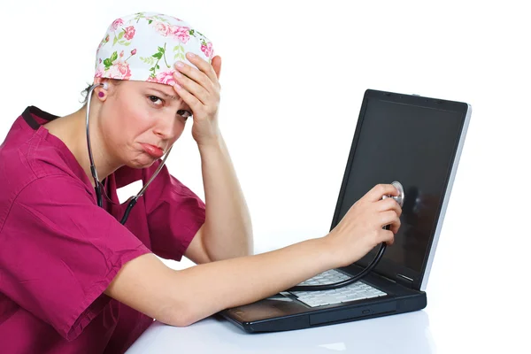 Sad female doctor checking laptop — Stock Photo, Image