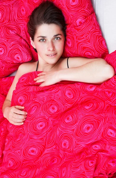Mladá žena v posteli — Stock fotografie