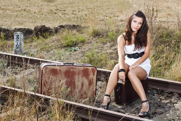 Young woman sitting on railroad — Stock Photo, Image