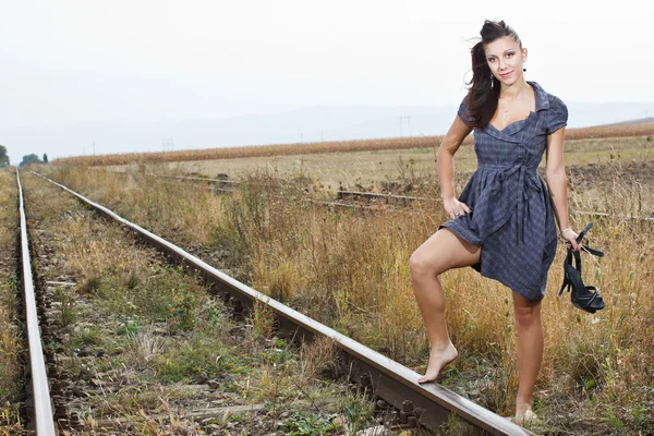 Schöne junge Frau auf der Eisenbahn — Stockfoto