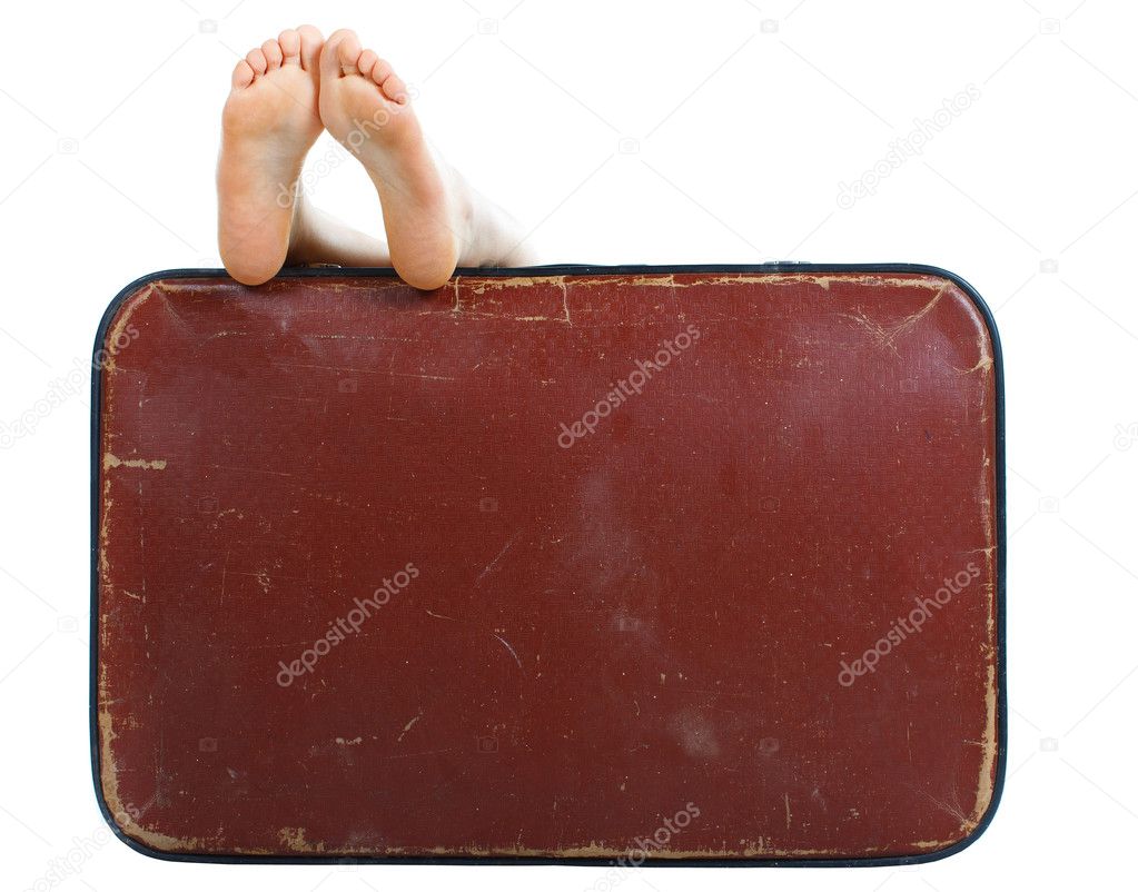 Old suitcase with naked female feet on top