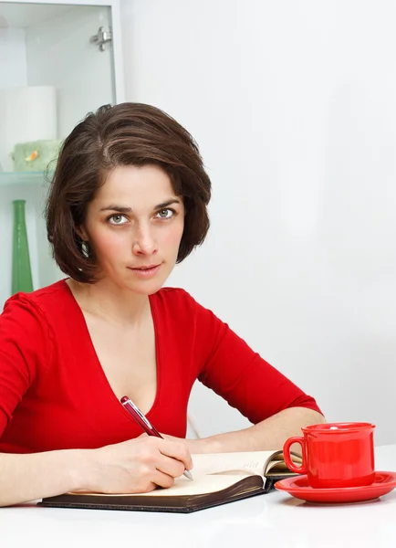Young woman at home writing — Stock Photo, Image