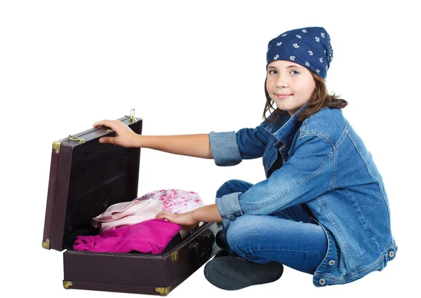 Söt flicka sitter med öppen resväska Stockbild