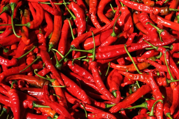 Uma cesta cheia de pimentas picantes frescas em um mercado chinês . — Fotografia de Stock