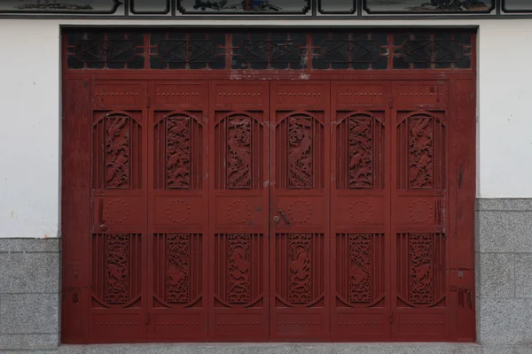 stock image A decorated red door in China.