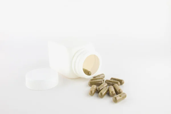 Herbal pill and white bottle — Stock Photo, Image