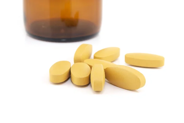 Vitamin C pills with medicine bottle background — Stock Photo, Image