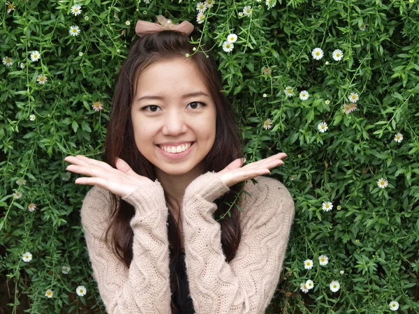 Una sonrisa de Asia hermosa niña en un fondo de naturaleza verde — Foto de Stock