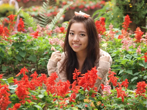Um sorriso da Ásia linda menina em um fundo de flo colorido — Fotografia de Stock