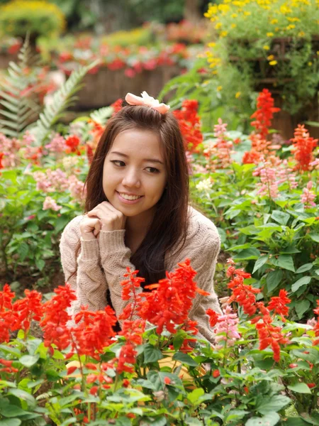 아시아 colorfull 꽃 배경에서 아름 다운 여자의 미소 — 스톡 사진