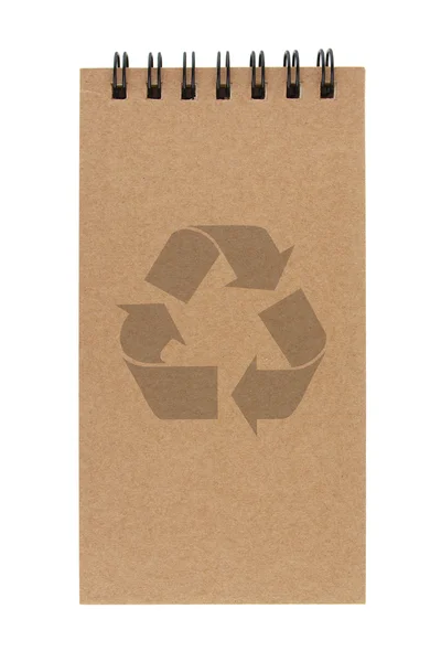 Kierrätyspaperi muistikirja, jossa on kierrätysmerkki valkoisella pohjalla — kuvapankkivalokuva