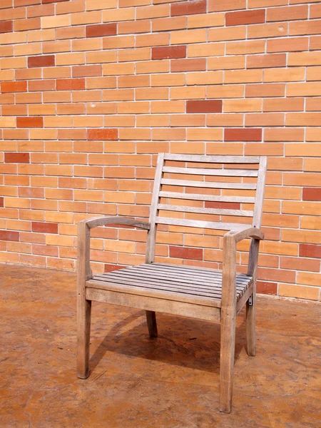 Скамейка против кирпичной стены — стоковое фото