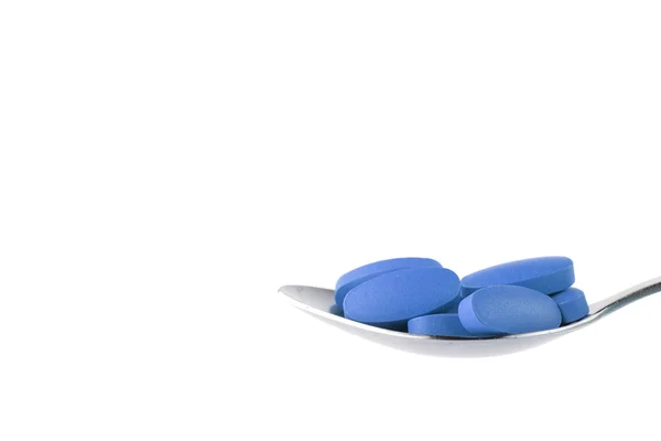 Blue tablet on the spoon — Stock Photo, Image