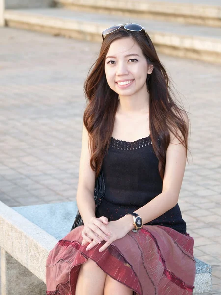 Portret atrakcyjny azjatycki kobieta siedzi na ławce w wartości nominalnej — Zdjęcie stockowe