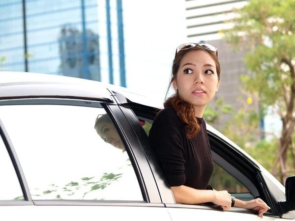 Молодая красивая азиатка смотрит на заднее сиденье машины — стоковое фото