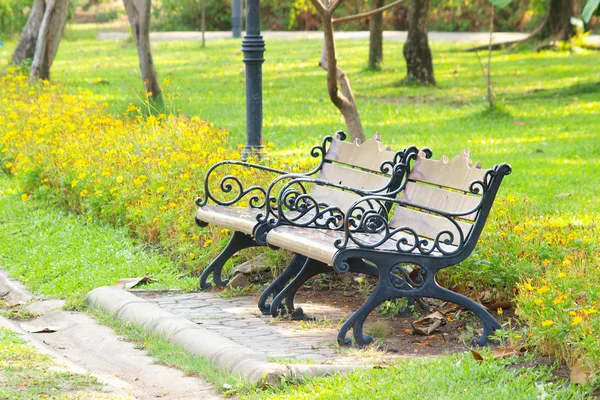Скамейки в парке с цветами — стоковое фото