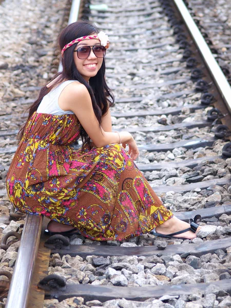 Молодая красивая азиатка сидит на железной дороге — стоковое фото