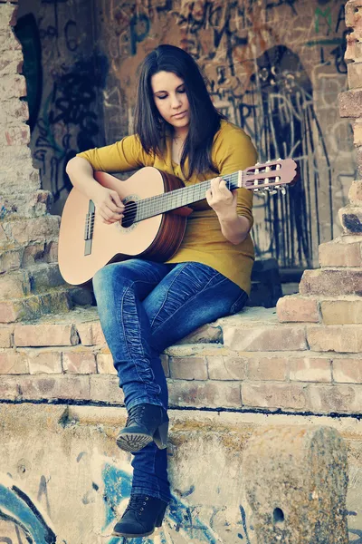 Mladá dívka si hraje na kytaru — Stock fotografie