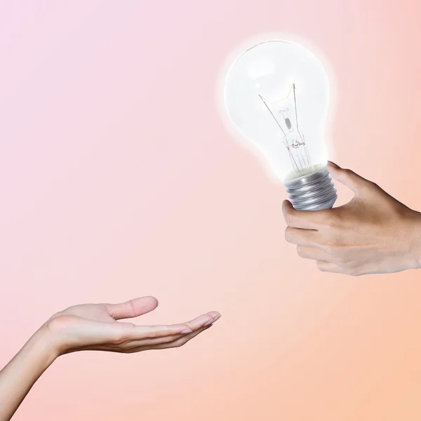 Hand gibt Glühbirne Licht, Transfer-Idee — Stockfoto