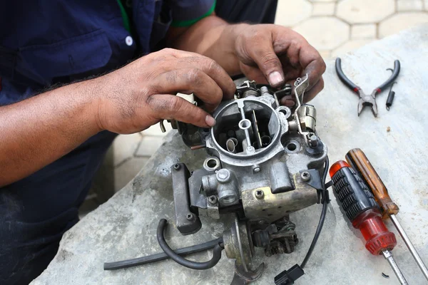 stock image Hand fixing car engine, caburator.