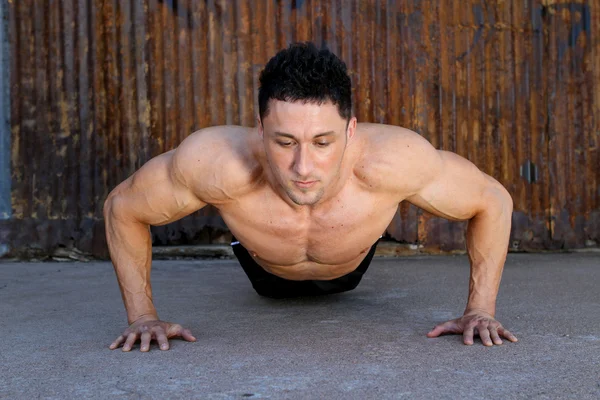Young caucasian male in sportswear doing push ups — Stock Photo, Image