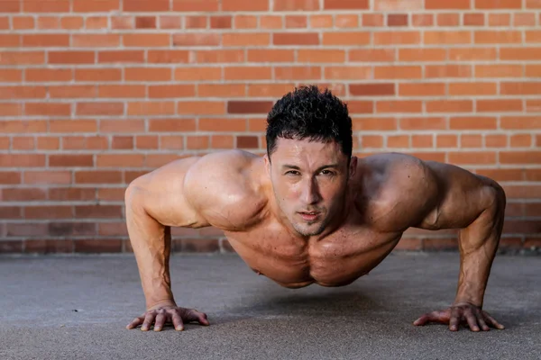 Young caucasian male in sportswear doing push ups — Stock Photo, Image