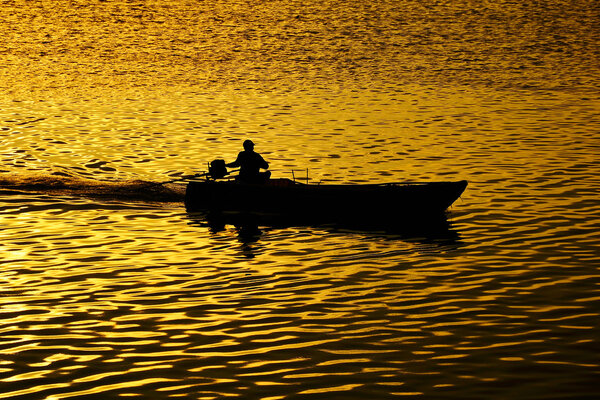 Silhouette fisherman with boat