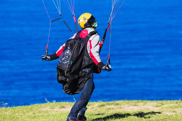 Homem controlando paraquedas em dia ventoso . — Fotografia de Stock
