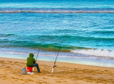 Man fishing on a beautiful beach setting clipart