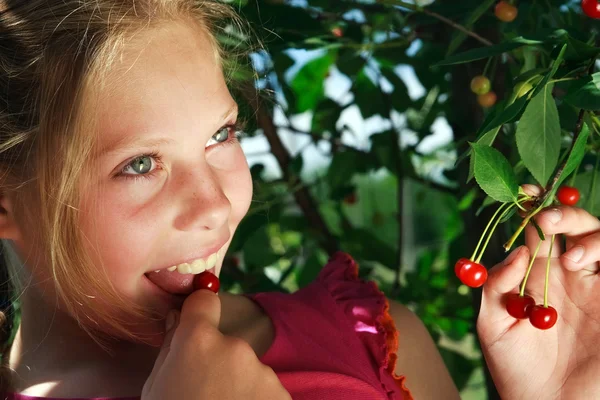 Menina feliz para saborear bagas de cereja vermelhas — Fotografia de Stock