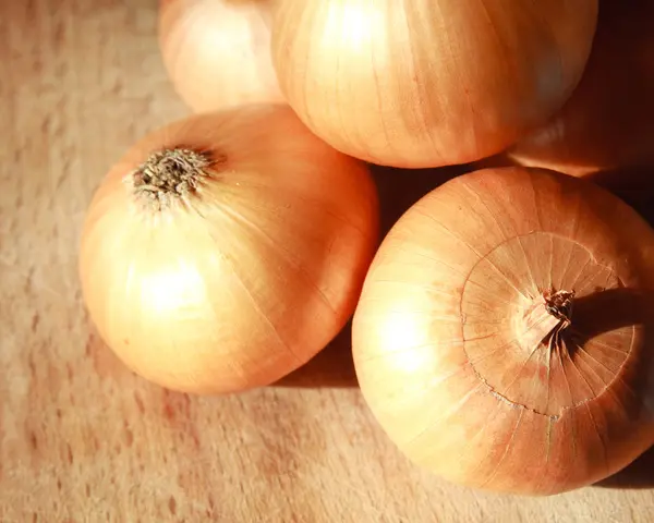 stock image Onions on wooden desk