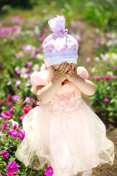 Close portrait little child playing in flowers field — Stock Photo, Image
