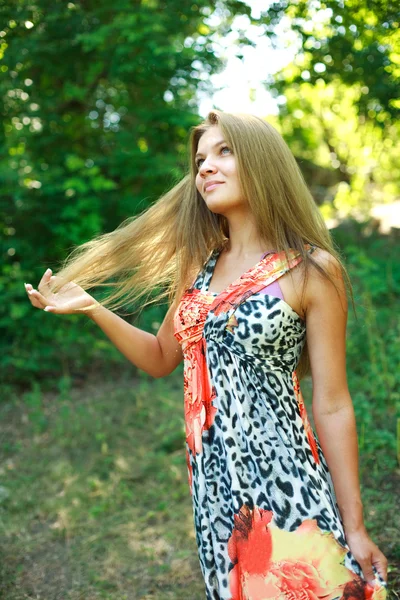 Vackra unga blonda kvinnan njuter en sommardag i gröna skogen — Stockfoto