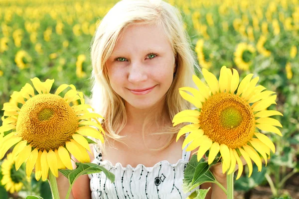Jovem loira de olhos verdes menina no campo dos girassóis — Fotografia de Stock