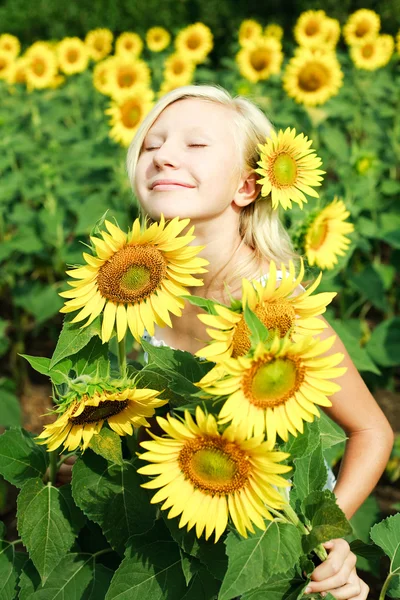 Ung flicka i fältet av solrosor — Stockfoto