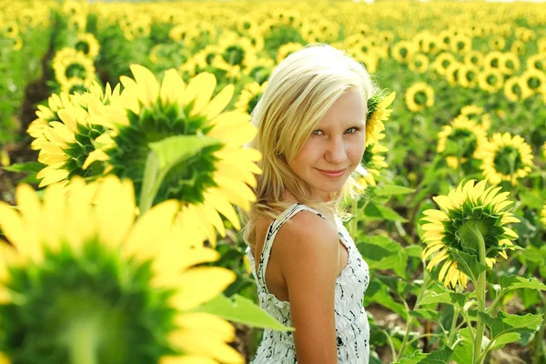Dromerige jong meisje op het gebied van zonnebloemen — Stockfoto