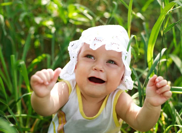 Happy baby girl having fun in green grass — Stock Photo, Image