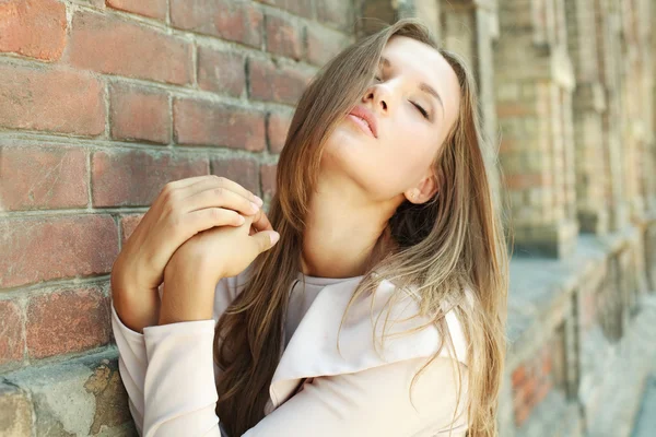 고 대 벽돌 벽 근처 열정적인 매력적인 젊은 여자 — 스톡 사진