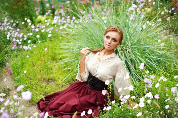 Mode flicka njuter en sommardag i blomma trädgård — Stockfoto