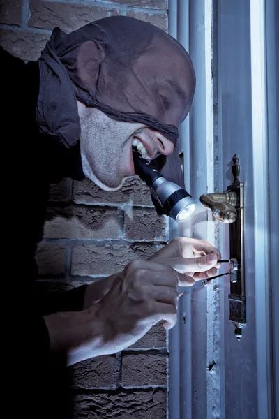 stock image Burglar picking door lock