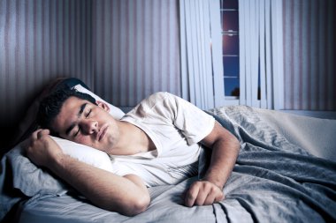 Man comfortably sleeping in his bed clipart