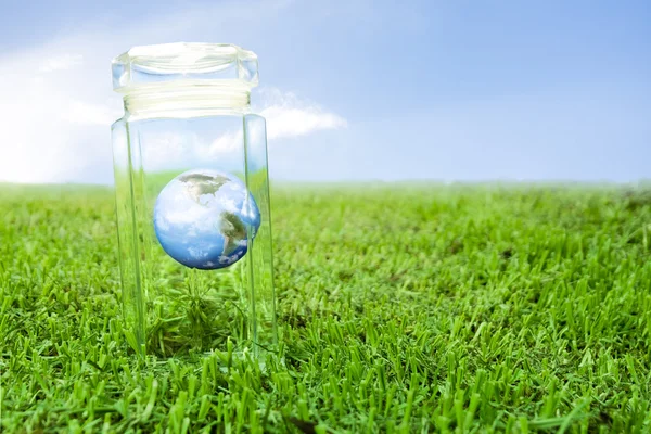 Protecting earth inside a crystal jar over grass, ideal for background — Stock Photo, Image